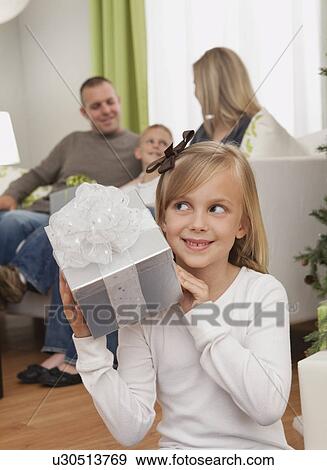 Stock Photo - Family with boy and girl (6-7, 8-9) celebrating christmas. Fotosearch