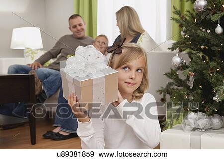 Stock Photo - Family with boy and girl (6-7, 8-9) celebrating christmas. Fotosearch