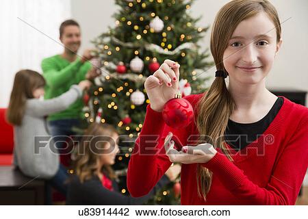Family with two children (8-9, 10-11) decorating Christmas tree View Large Photo Image Stock Image - Family with two children (8-9, 10-11) decorating Christmas tree. Fotosearch
