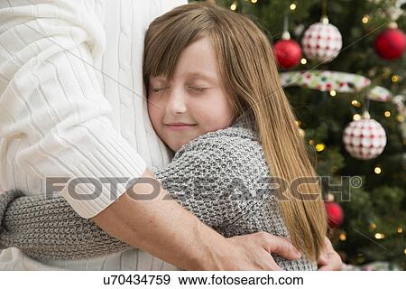 Father and daughter (8-9) embracing near Christmas tree View Large Photo Image Stock Photo - Father and daughter (8-9) embracing near Christmas tree. Fotosearch