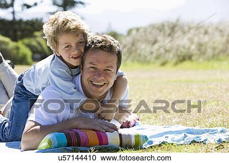 Father and son (8-9) laying on lawn, portrait View Large Photo Image Stock Image - Father and son (8-9) laying on lawn, portrait. Fotosearch