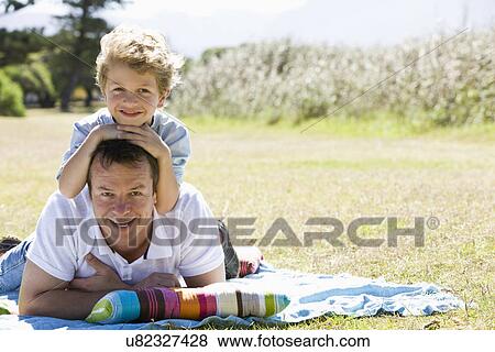 Father and son (8-9) laying on lawn, portrait View Large Photo Image Stock Photo - Father and son (8-9) laying on lawn, portrait. Fotosearch
