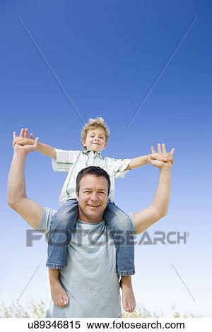 Father carrying son (8-9) on shoulders View Large Photo Image Stock Photography - Father carrying son (8-9) on shoulders. Fotosearch