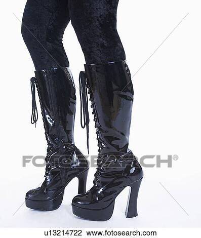 Stock Image - Female legs in high heeled black leather boots. Fotosearch