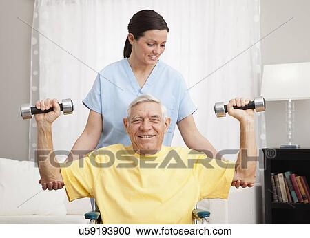 Female nurse assisting senior man exercising in retirement home View Large Photo Image Stock Image - Female nurse assisting senior man exercising in retirement home. Fotosearch