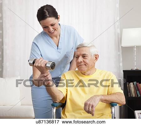 Female nurse assisting senior man exercising in retirement home View Large Photo Image Stock Photo - Female nurse assisting senior man exercising in retirement home. Fotosearch