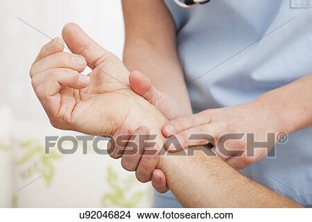 Female nurse taking pulse of senior man in retirement home View Large Photo Image Picture - Female nurse taking pulse of senior man in retirement home. Fotosearch