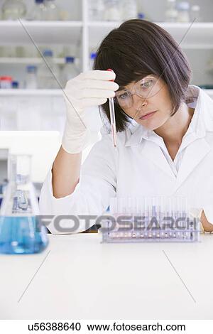 Female scientist looking at test tubes in laboratory View Large Photo Image Stock Image - Female scientist looking at test tubes in laboratory. Fotosearch