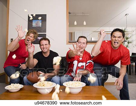 Four friends throwing popcorn in living room View Large Photo Image Stock Image - Four friends throwing popcorn in living room. Fotosearch