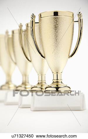 Four gold trophies in a row View Large Photo Image Stock Image - Four gold trophies in a row. Fotosearch