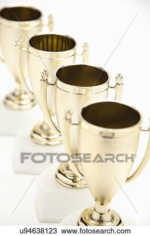 Four gold trophies in a row View Large Photo Image Stock Image - Four gold trophies in a row. Fotosearch