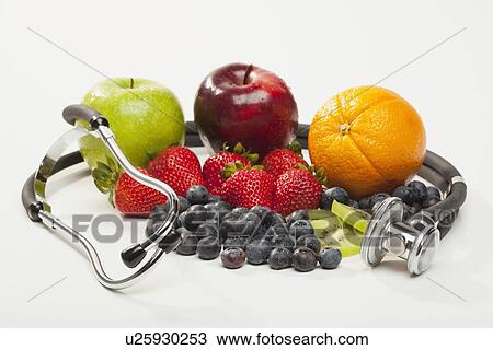 Stock Image - Fruits with stethoscope on white background. Fotosearch