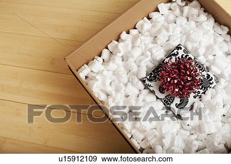 Stock Photo - Gift packed in wrapping paper ready to send, studio shot. Fotosearch
