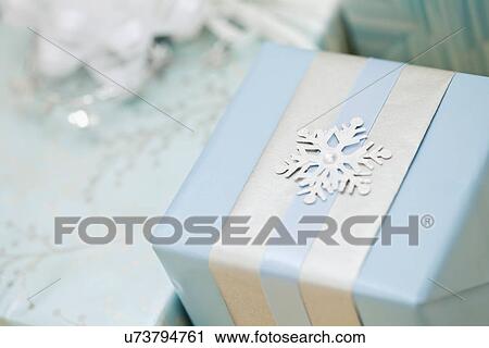 Stock Image - Gift with snowflake decoration, studio shot. Fotosearch