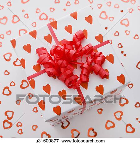 Gift wrapped in heart pattern paper and red ribbon View Large Photo Image Stock Photo - Gift wrapped in heart pattern paper and red ribbon. Fotosearch