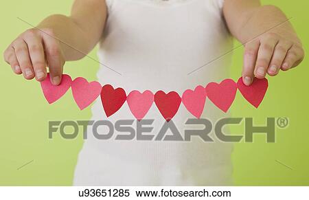 Girl (10-11) holding paper hearts in a row View Large Photo Image Stock Photography - Girl (10-11) holding paper hearts in a row. Fotosearch