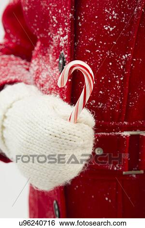 Stock Photograph - Girl (12-13) holding candy cane. Fotosearch