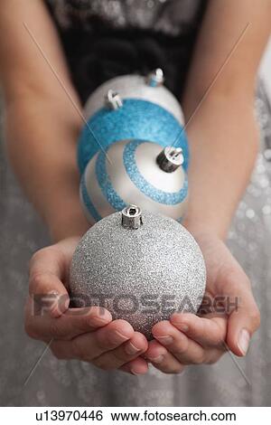Stock Photograph - Girl (12-13) holding christmas bulbs. Fotosearch