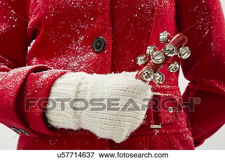 Stock Photo - Girl (12-13) holding jingle bells. Fotosearch