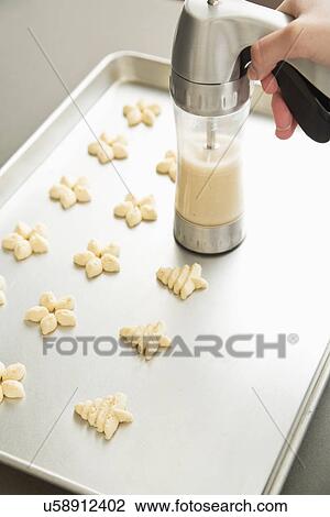 Stock Image - Girl (12-13) preparing spritz cookies. Fotosearch
