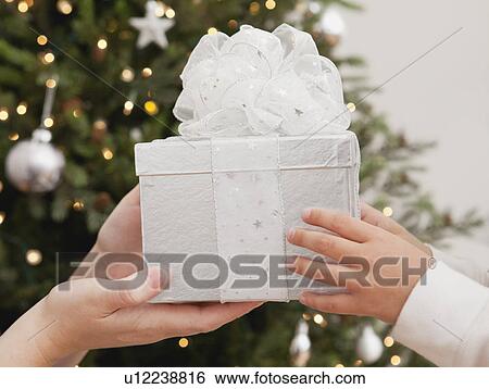 Stock Photograph - Girl (6-7) receiving christmas present from mother. Fotosearch