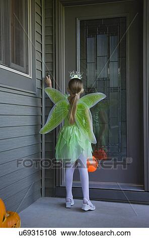 Girl (8-9) wearing fairy costume trick or treating, rear view View Large Photo Image Stock Photo - Girl (8-9) wearing fairy costume trick or treating, rear view. Fotosearch