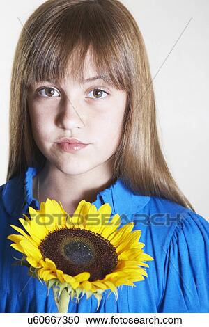 Girl holding sunflower, portrait View Large Photo Image Stock Image - Girl holding sunflower, portrait. Fotosearch