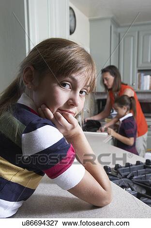 Stock Photo - Girls helping mother in kitchen. Fotosearch