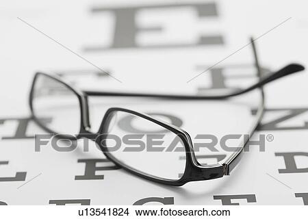 Glasses on eye chart, studio shot View Large Photo Image Picture - Glasses on eye chart, studio shot. Fotosearch