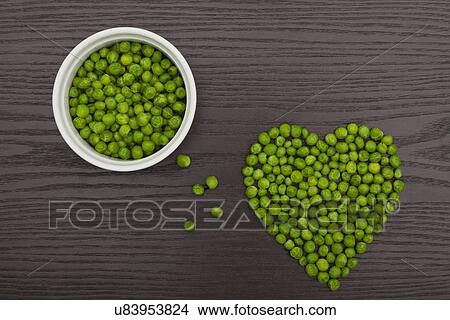 Picture - Green peas in heart shape. Fotosearch