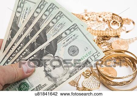 Hand holding banknotes above heap of gold jewelry View Large Photo Image Stock Image - Hand holding banknotes above heap of gold jewelry. Fotosearch