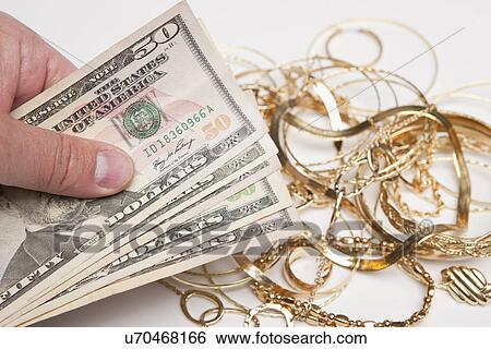Hand holding fan of fifty dollar bills against golden jewelry View Large Photo Image Stock Photograph - Hand holding fan of fifty dollar bills against golden jewelry. Fotosearch
