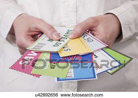 Stock Photograph - Hands holding coupons. Fotosearch