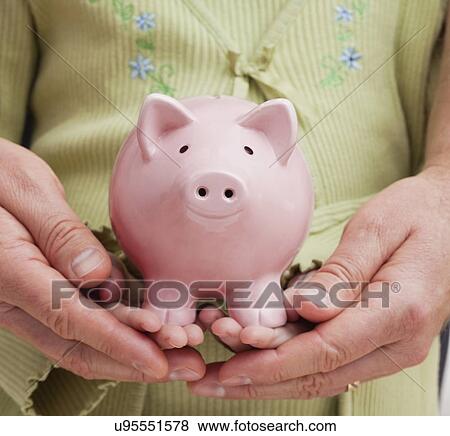 Stock Photo - Hands holding piggybank. Fotosearch
