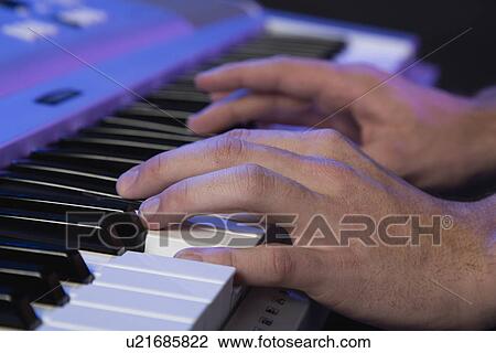Stock Image - Hands of male musician playing keyboard. Fotosearch