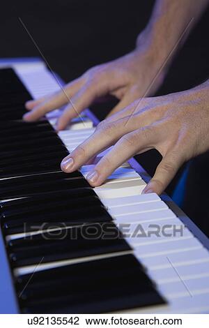 Stock Image - Hands of male musician playing keyboard. Fotosearch