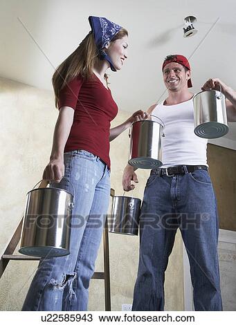 Happy couple holding paint cans View Large Photo Image Stock Image - Happy couple holding paint cans. Fotosearch