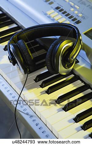 Headphones lying on keyboard View Large Photo Image Stock Image - Headphones lying on keyboard. Fotosearch