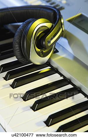 Headphones lying on keyboard View Large Photo Image Stock Photo - Headphones lying on keyboard. Fotosearch