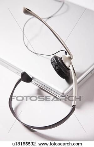 Stock Image - Headset on laptop on white background. Fotosearch