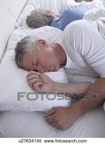 High angle view of mature couple sleeping in bed View Large Photo Image Stock Photography - High angle view of mature couple sleeping in bed. Fotosearch