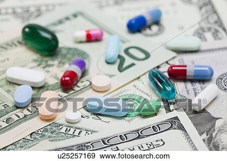Stock Photo - High angle view of pills on US banknotes, studio shot. Fotosearch