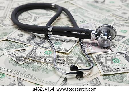 Picture - High angle view of stethoscope on US banknotes, studio shot. Fotosearch