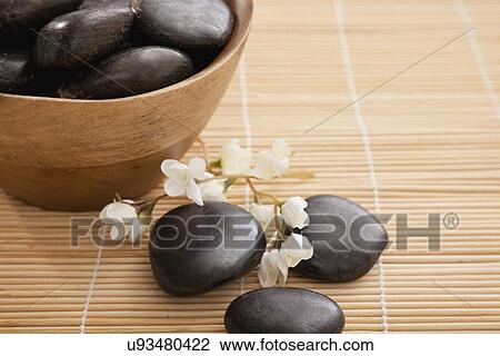 Stock Image - hot stone therapy stones in spa, Studio shot. Fotosearch