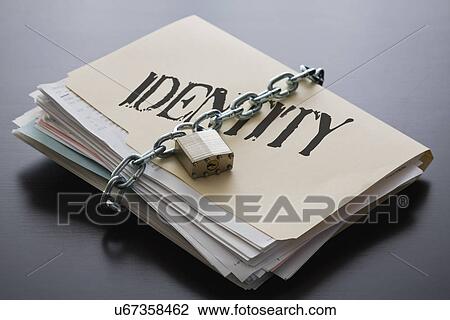 Stock Image - Identity folder with files closed with chain and padlock. Fotosearch