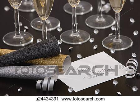 Stock Image - Invitation and champagne flutes on table. Fotosearch