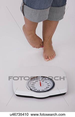 Low section of woman standing in front of weight scales View Large Photo Image Stock Image - Low section of woman standing in front of weight scales. Fotosearch