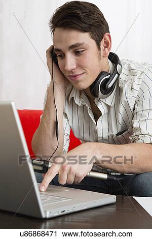 Stock Image - Male musician composing using laptop. Fotosearch