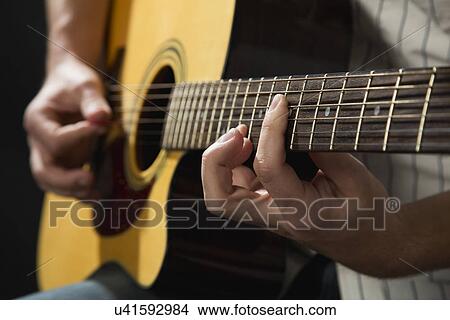 Male musician playing guitar and singing on stage View Large Photo Image Picture - Male musician playing guitar and singing on stage. Fotosearch