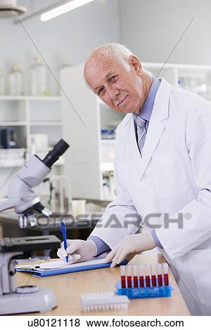 Stock Photo - Male scientist doing research in laboratory, portrait. Fotosearch